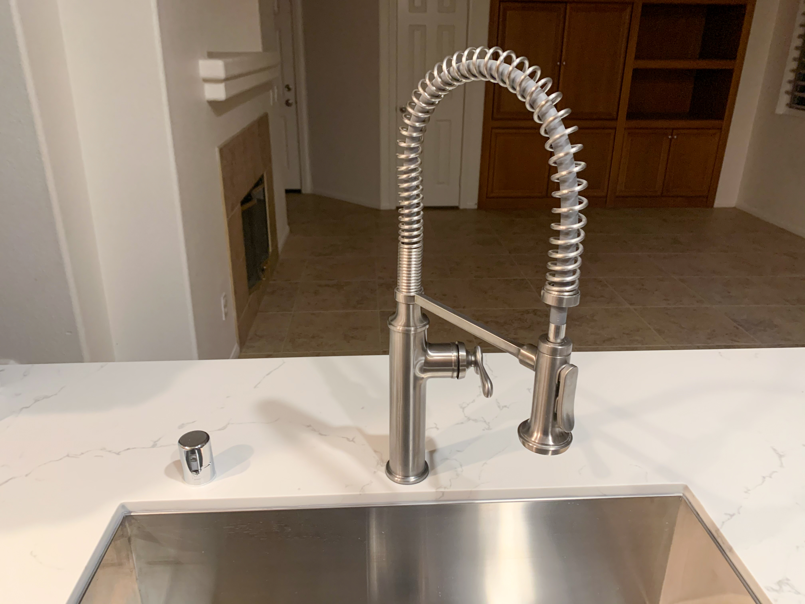 residential-plumbing-services-3 A residential plumber shows off a newly installed kitchen faucet as a part of a plumbing project.