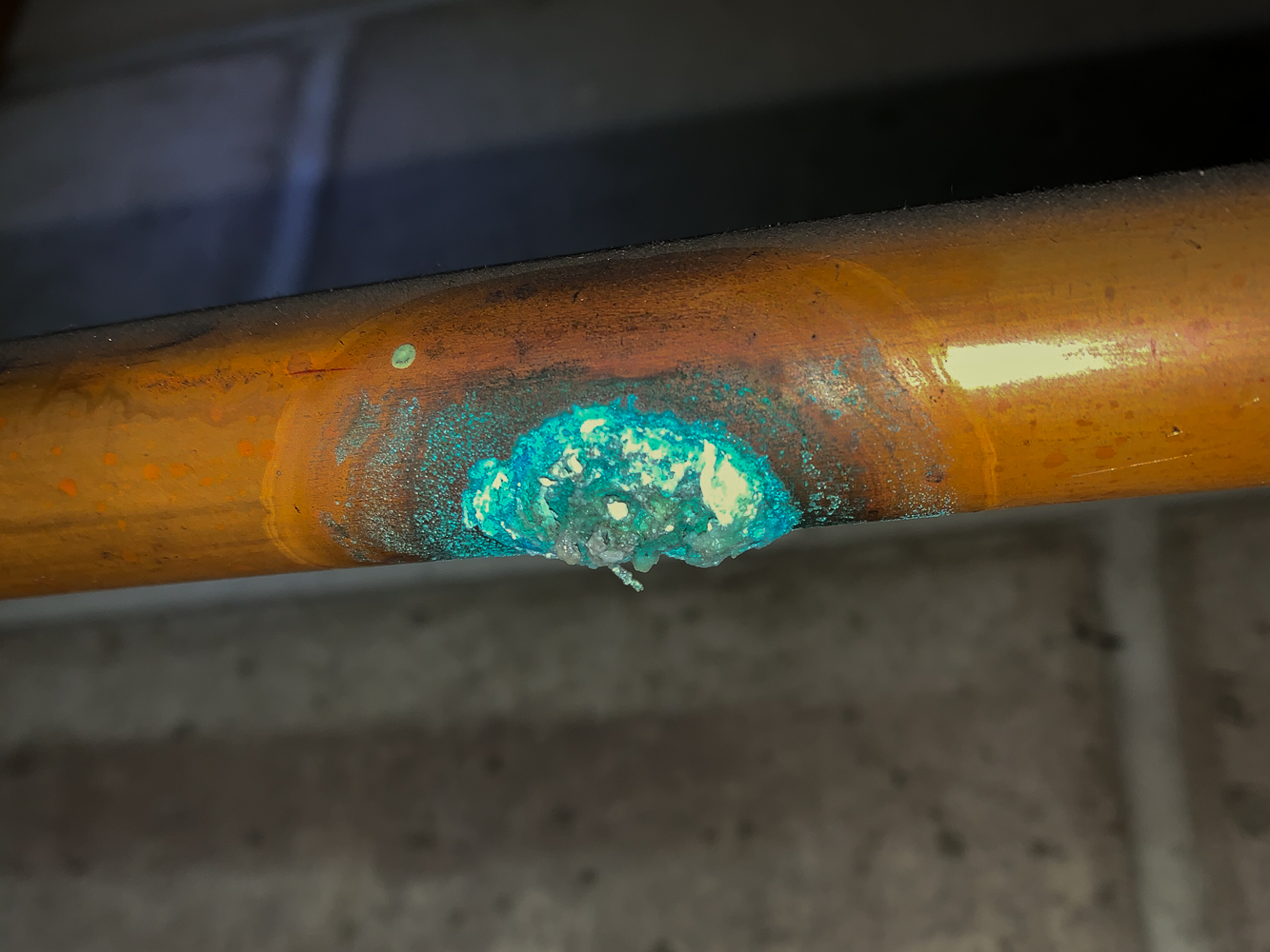 A corroded copper water pipe is leaking due to several pinhole leaks, creating the need for a whole-home repipe.