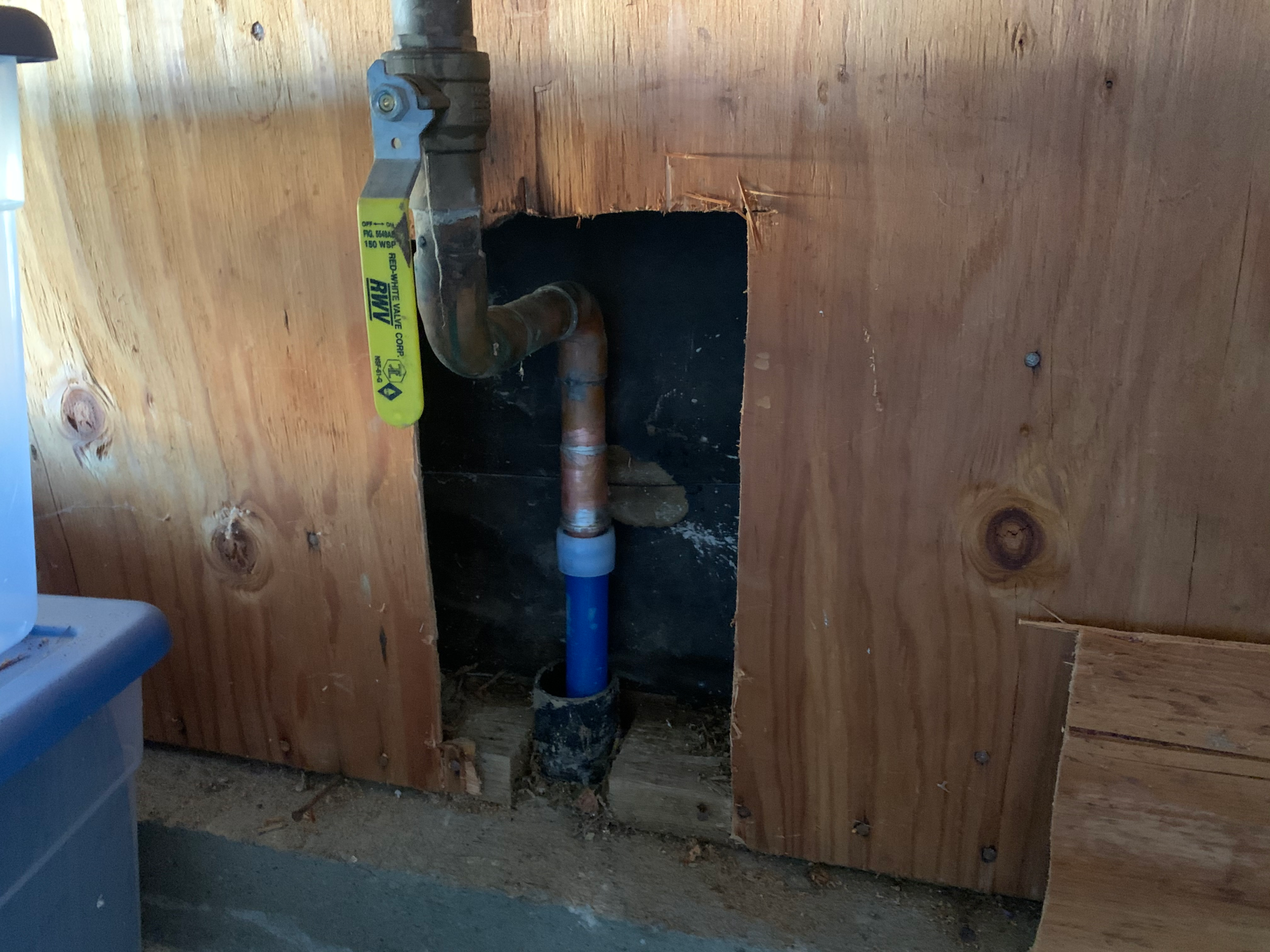 A completed PEX main water service line replacement shows the piping enter the garage near the main shut off valve.