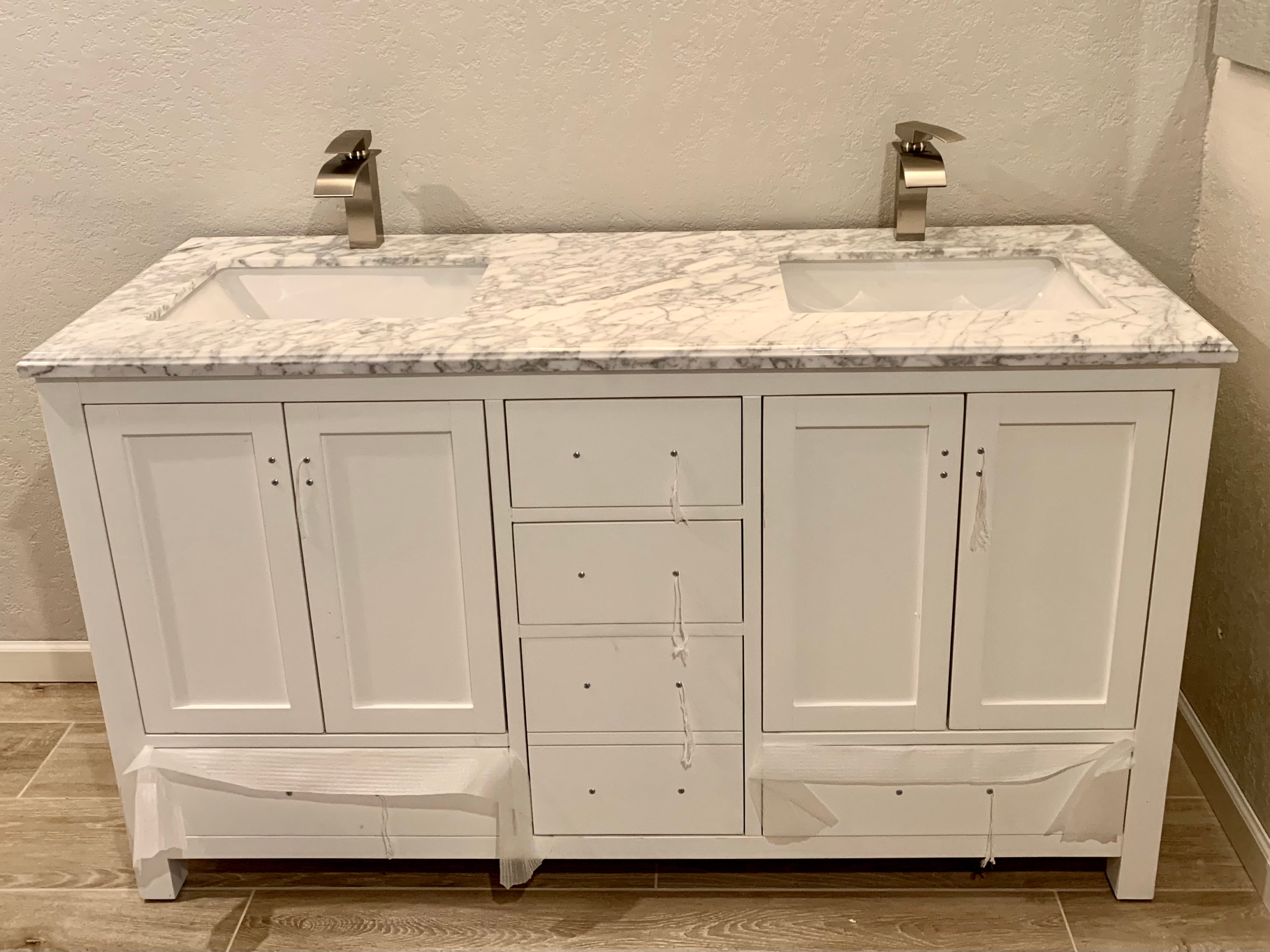 bathroom-vanity-installation A double-sink vanity with stone counter is being installed in the primary bathroom of an Escondido home.