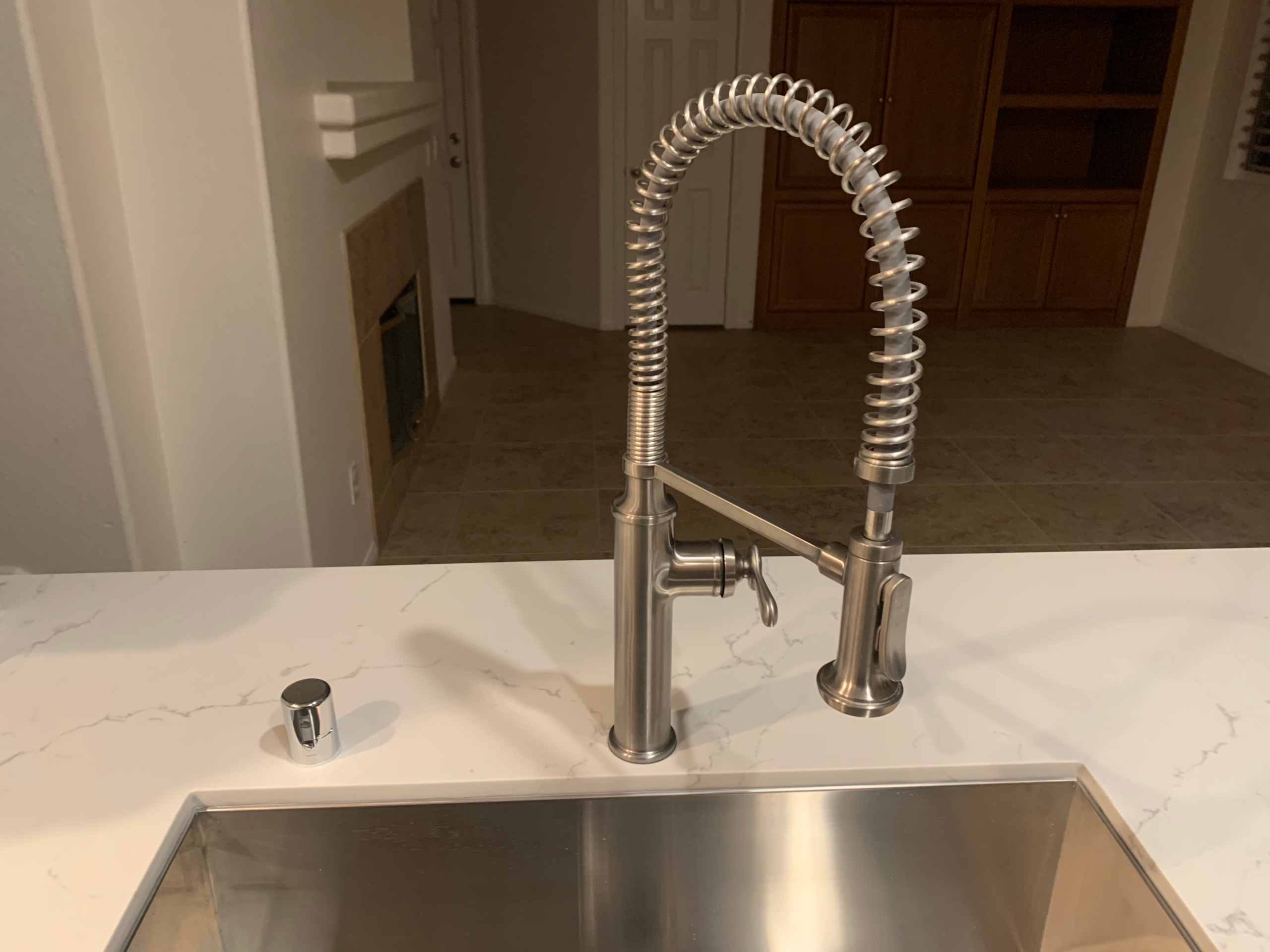 A new, single-handle kitchen faucet with stainless finish and pull-down sprayer has been installed in a home in Escondido, CA.