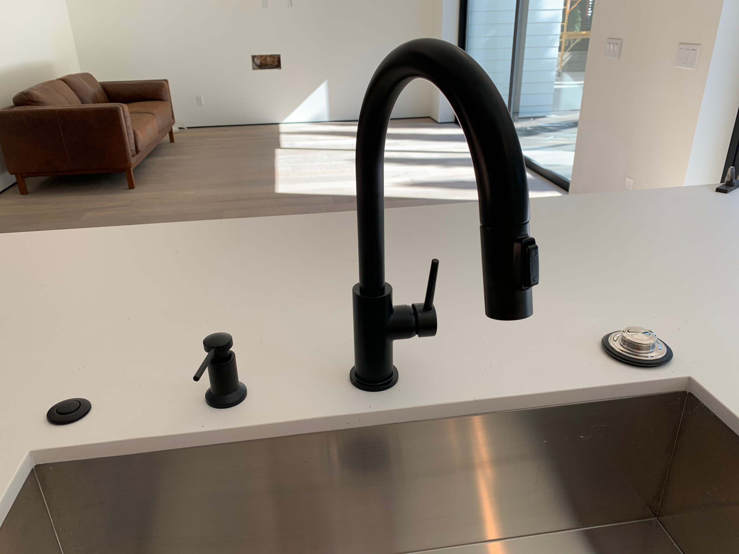 kitchen-faucet-repair-installation A new kitchen faucet with satin black finish and pull-out sprayer is installed in an Escondido home during a remodel.