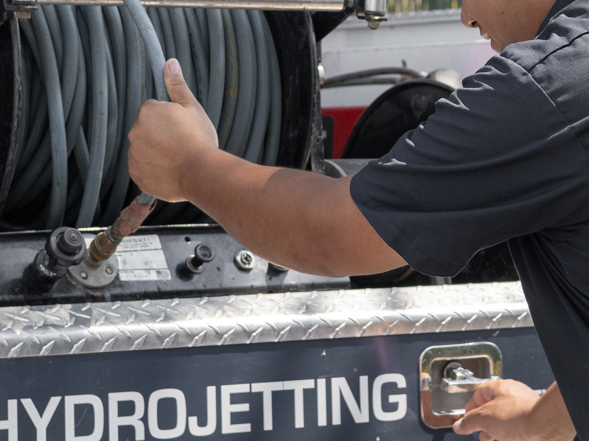A plumber prepares his equipment for hydro-jetting service in Escondido, CA.